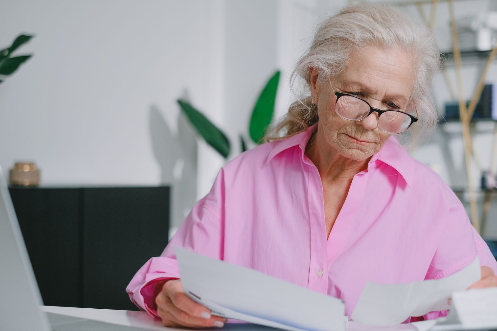 Reading a contract at a desk with reading glasses